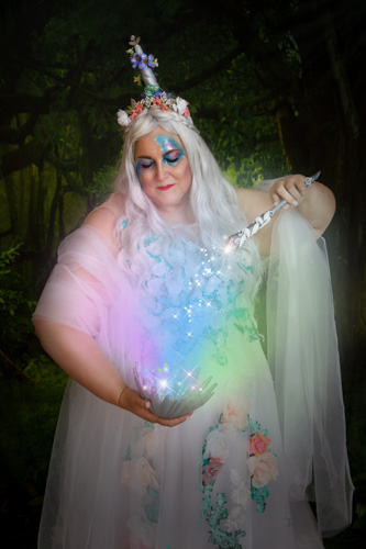 Woman in a white fantasy dress holding a magic wand with magic spilling from it into a bowl.