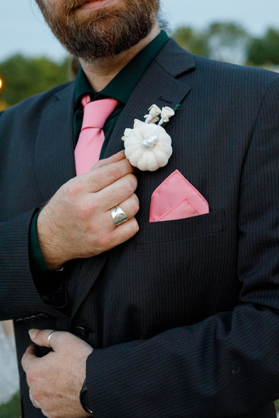 A close view of the groom's white floral boutonniere